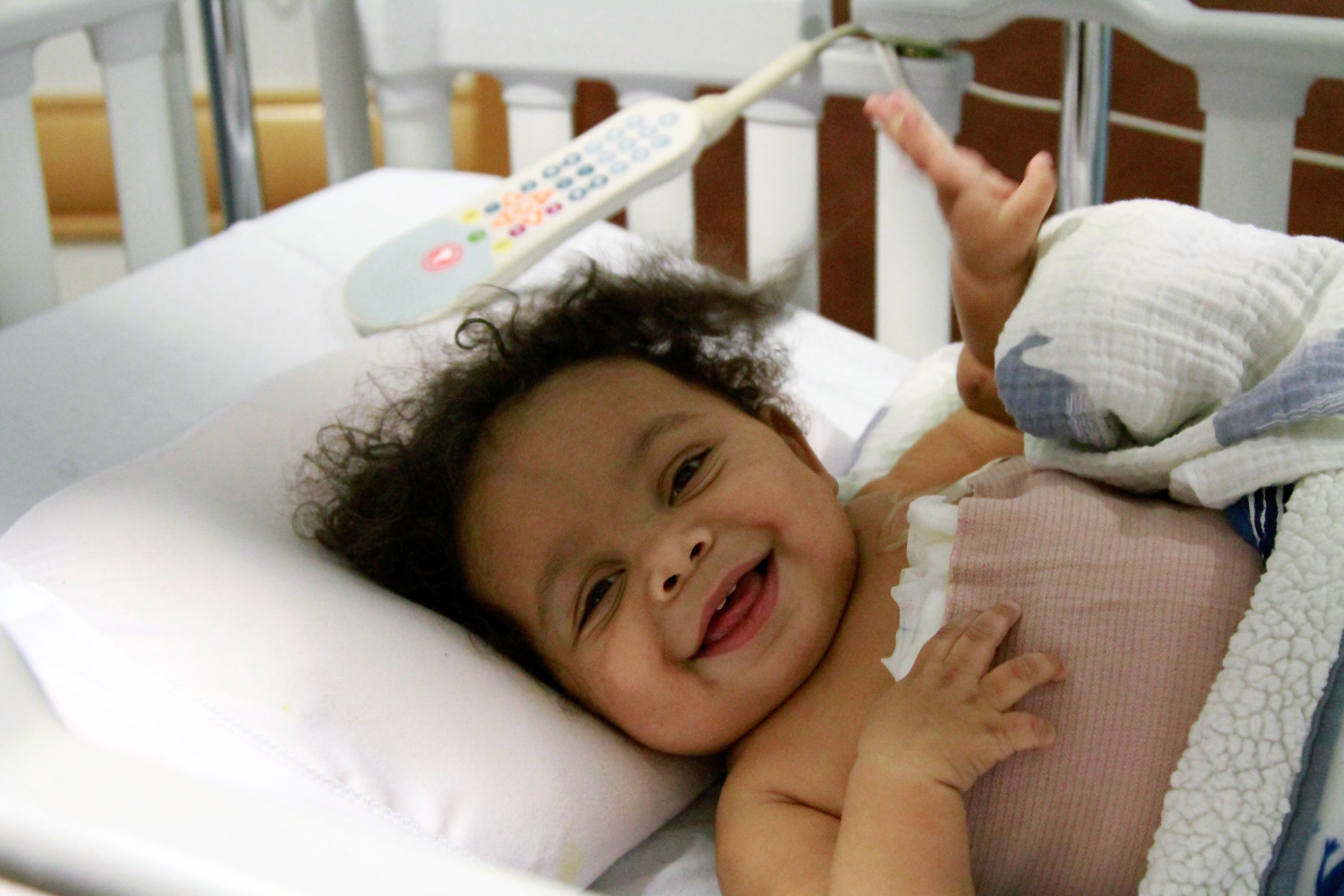 Baby in hospital bed smiling
